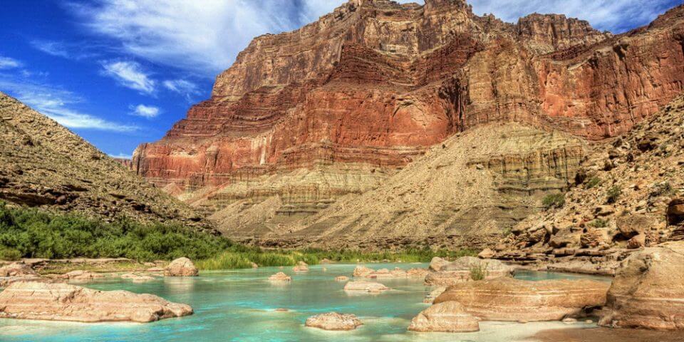 Supai's Travertine Rock in the background of crystal blue waters.