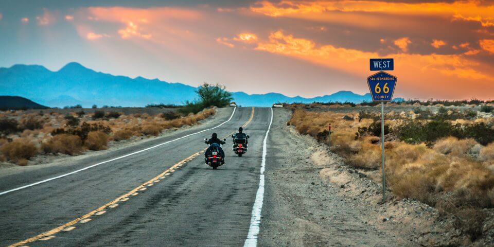 Bikers ride into the sunset on Route 66 in California.