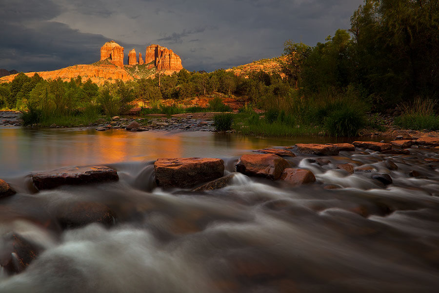 A beautiful shot of blurred running water with Cathedral Rock in the background and moonsoon sky above it.Flickr User Guy Schmickle