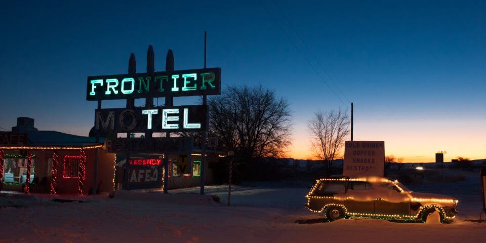 The Frontier Motel lit up at night.
