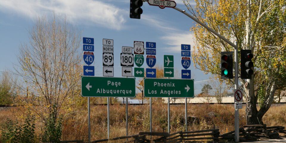 Two street signs for Page, Albuquerque, Phoenix, an Los Angeles along the hightway.