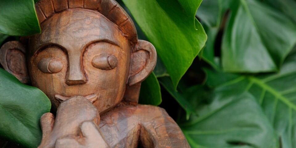 A wooden sculpture of a Menehune at a Disney resort.