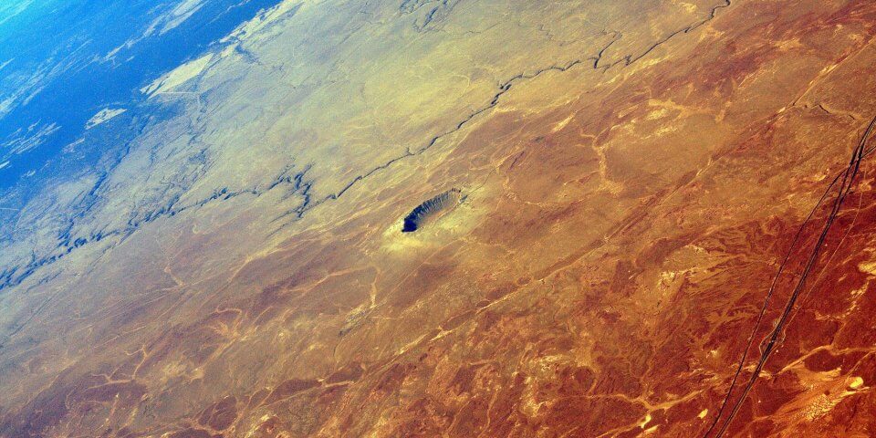 An extreme long distance aerial shot of the Meteor Crater (Barringer Crater).