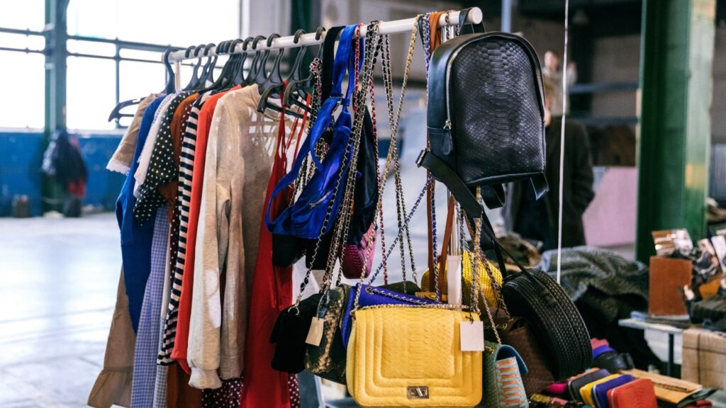 Clothes on the rail on the autumn fashion designer market. Garage sale, reuse the clothes, second hand and eco consumering