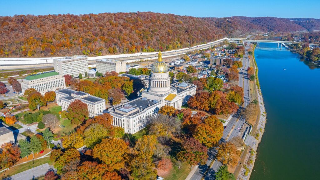 An aerial view of the West Virginia State Capitol Building and downtown Charleston with fall foliage.