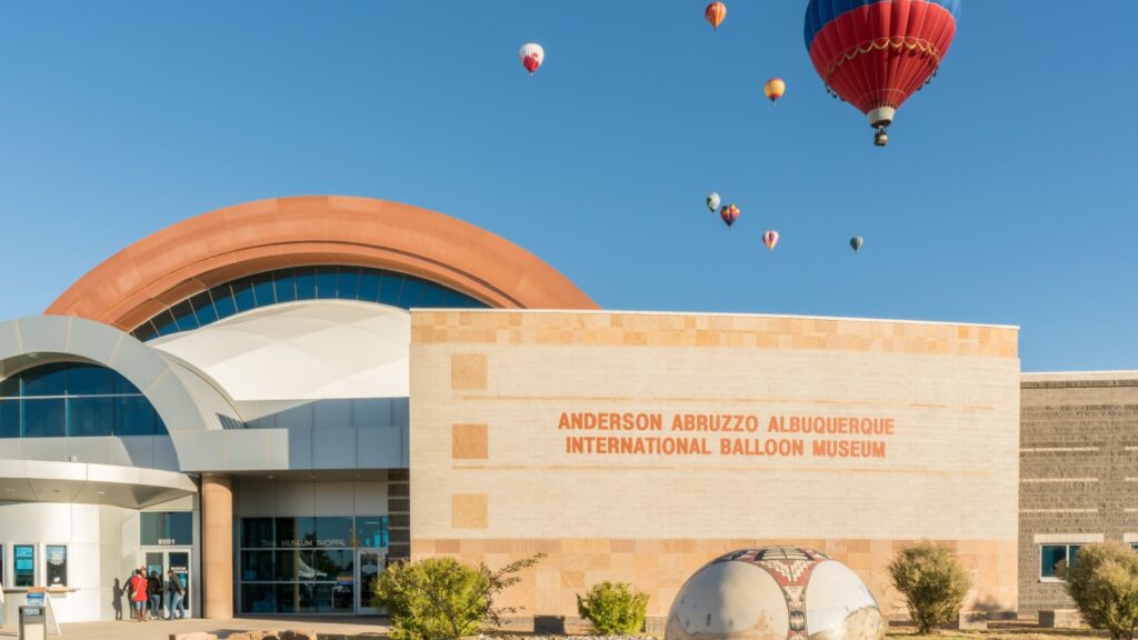 Colorful hot air balloons floating above the Anderson Abruzzo Albuquerque International Balloon Museum, at the Albuquerque International Balloon Fiesta.