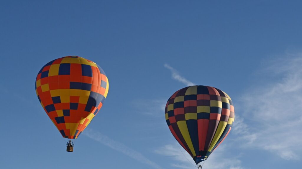 Hot air balloons fly through the sky during the Natchez Balloon Festival. 
